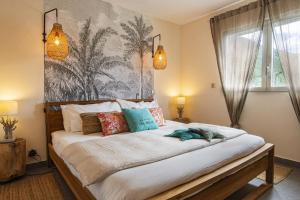 sypialnia z dużym łóżkiem z kolorowymi poduszkami w obiekcie Bleu Marine Beach w mieście Grand Case