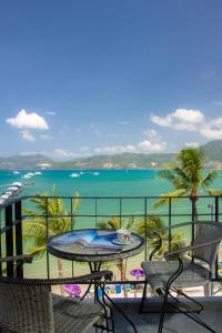 a balcony with a table and chairs and the ocean at Patong Signature Boutique Hotel in Patong Beach