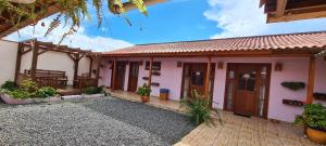 a house with pink walls and wooden doors at Pousada Alternativa KeKe in Urubici