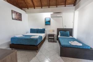 ein Schlafzimmer mit 2 Betten und einem Waschbecken darin in der Unterkunft Sunset Hotel in San Andrés