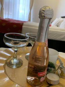 una botella de alcohol en una mesa con una copa de vino en CHIC CITY Rooms, en Sighişoara