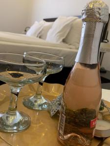 Una botella de champán y dos copas en una mesa. en CHIC CITY Rooms, en Sighişoara