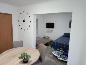 een kamer met een tafel en een slaapkamer met een bed bij Apartman Borna in Otočac