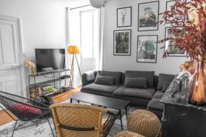 a living room with a couch and a tv at La Demeure de Chemonton in Blois