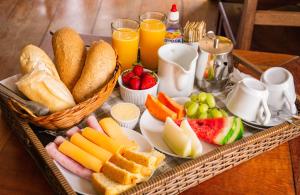 una bandeja de comida con pan y fruta en una mesa en Pousada Água Viva, en Paraty