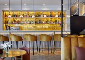 a restaurant with a bar with brown stools at Erinvale Estate Hotel & Spa in Somerset West