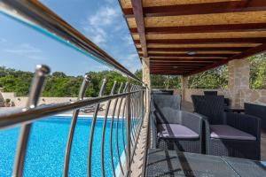 a balcony with chairs and a swimming pool at Apartments Karen in Vinišće