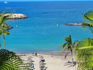 a beach with a group of people and the ocean at Flamingo Beach Mate in Adeje