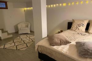 a bedroom with a bed and a chair and lights at Villa des Oliviers avec piscine in Chassagny