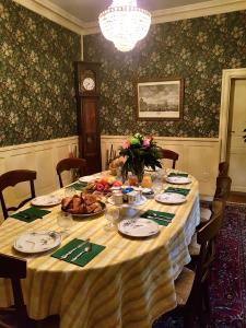 a dining room with a table with food and a clock at Chez Louise in Albi