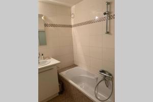 y baño con bañera y lavamanos. en Two bedroom apartment - 50 meters from beach and KYC, en Koksijde