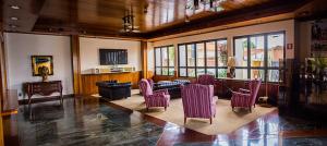 a living room with purple chairs and a couch at Hotel Marques in Araras