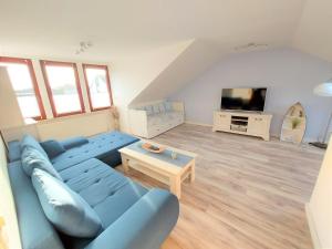 a living room with a blue couch and a tv at Ferienwohnung Seestern 21 in Bremerhaven