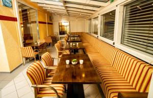 una fila de mesas y sillas en un restaurante en Parkhotel Lindenhof - KOSTENLOSE PARKPLÄTZE en Offenbach