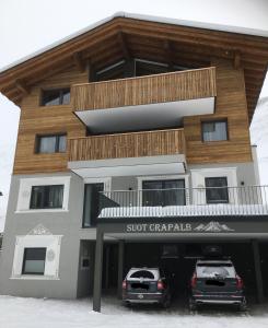 two cars parked in front of a building at Suot Crapalb in Samnaun