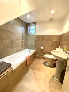 uma casa de banho com uma banheira, um WC e um lavatório. em Laurel House em Cheltenham