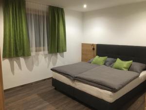 ein Bett mit grünen Kissen im Schlafzimmer in der Unterkunft Suot Crapalb in Samnaun