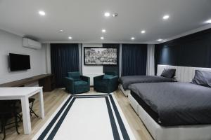 Schlafzimmer mit einem Bett, einem Schreibtisch und einem TV in der Unterkunft Kubbe House in Istanbul