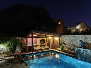 - une piscine dans l'arrière-cour d'une maison la nuit dans l'établissement "Entre Mer et Montagne", à Le Tampon