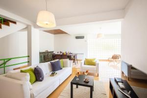 un soggiorno con divano bianco e tavolo di Villa Marina ad Albufeira