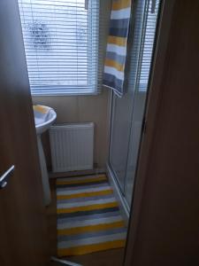 a small bathroom with a shower and a sink at Haggerston Castle 3 Bedroom Deluxe Holiday Home in Cheswick