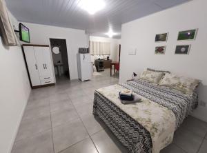 Casa em Florianópolis في فلوريانوبوليس: غرفة نوم بسرير ومطبخ مع ثلاجة