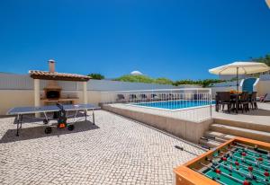 a ping pong table on a patio next to a pool at Villa Casa Castelo by Algarve Vacation in Albufeira