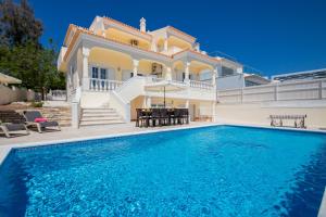 a villa with a swimming pool in front of a house at Villa Casa Castelo by Algarve Vacation in Albufeira