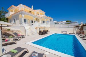 a villa with a swimming pool in front of a house at Villa Casa Castelo by Algarve Vacation in Albufeira