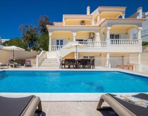 a villa with a swimming pool in front of a house at Villa Casa Castelo by Algarve Vacation in Albufeira
