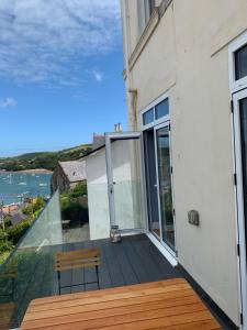 a balcony with a bench and a view of the water at Flat 3, Glenthorne House, Salcombe in Salcombe