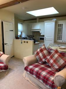 a living room with two couches and a kitchen at courtyard cottage in Kendal