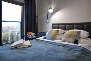 een slaapkamer met een groot bed en een groot raam bij Mennica Residence Apartments by P&O Serviced Apartments in Warschau