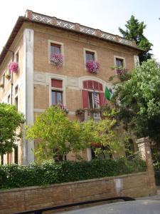 un edificio de ladrillo con flores en las ventanas en Villa Elda Boutique Hotel, en Siena