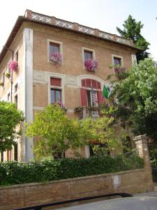 um edifício de tijolos com caixas de flores nas janelas em Villa Elda Boutique Hotel em Siena
