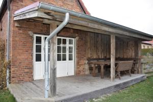 a porch of a brick building with a picnic table at Ferienwohnung/Haus in Welzin in Damshagen