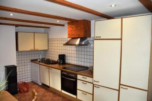 a kitchen with white cabinets and a stove top oven at Ferienwohnung/Haus in Welzin in Damshagen