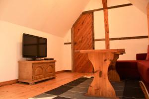 a living room with a television and a wooden table at Ferienwohnung/Haus in Welzin in Damshagen