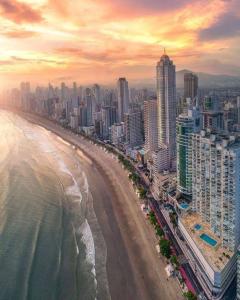 uma vista aérea de uma praia com edifícios e o oceano em Hotel Di Sica em Balneário Camboriú