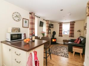 a kitchen with a microwave and a living room at Wee Woody in Bentley