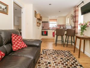 a living room with a couch and a kitchen at Wee Woody in Bentley