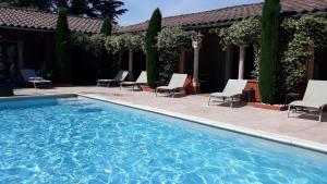 una piscina con sedie e un patio di Couleurs du Sud a Vallon-Pont-dʼArc