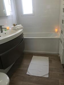 a bathroom with a sink and a tub and a white towel at Maison 4 chambres jardin et parking in Déols +20 photos