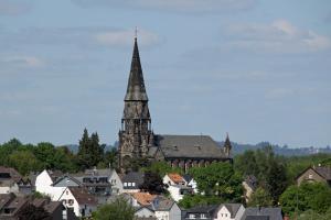 eine Kirche mit Kirchturm in einer Stadt mit Häusern in der Unterkunft Ferienwohnung Bella in Koblenz