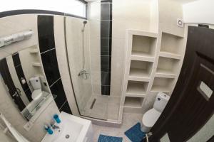 a bathroom with a shower and a sink and a mirror at Etiquette Studios Mamaia in Constanţa