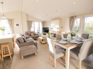 a living room with a table and chairs at Serenity Lodge in Wemyss Bay
