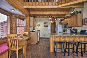 a kitchen with wooden cabinets and a table and chairs at Rustic Village Lake Cabin Escape with Deck and Grill! in Pagosa Springs