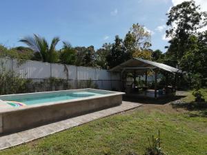 un patio trasero con piscina y cenador en Tropical Housing by El Rodeo - Puerto Jimenez Centro, en Puerto Jiménez