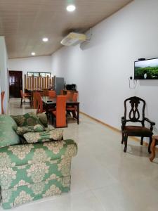 sala de estar con sofá y mesa con sillas en Tropical Housing by El Rodeo - Puerto Jimenez Centro, en Puerto Jiménez