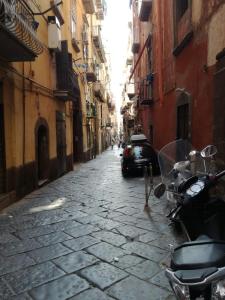 un vicolo con uno scooter parcheggiato in strada di Albert's House a Napoli
